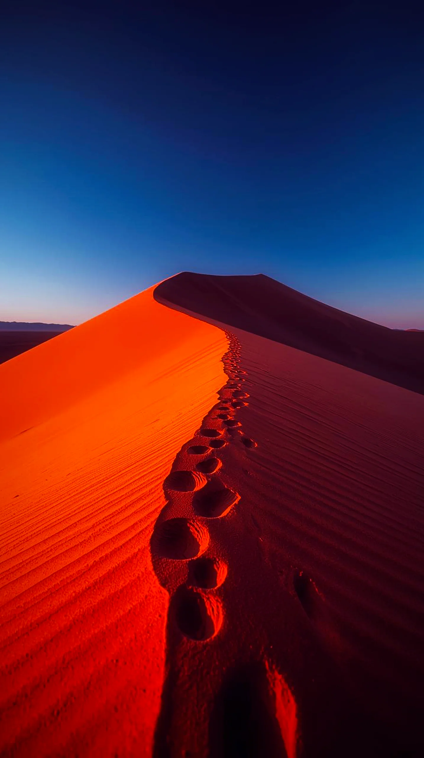 A beautiful 4K mobile wallpaper showing footprints leading up a vibrant orange desert sand dune under a blue sky.