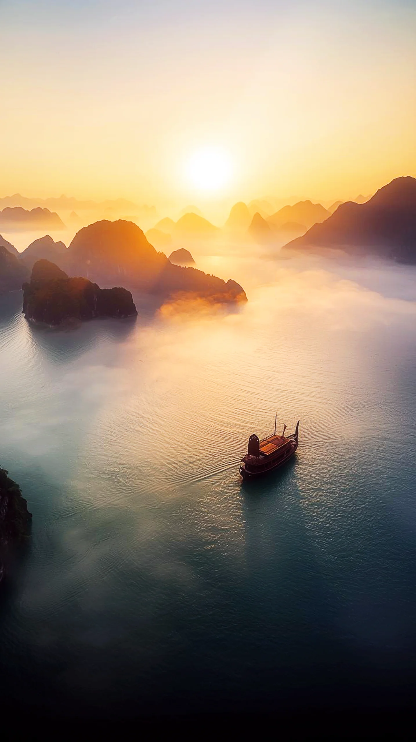 4K iPhone wallpaper of a boat sailing on calm water during sunrise, surrounded by misty mountains. A beautiful 4K