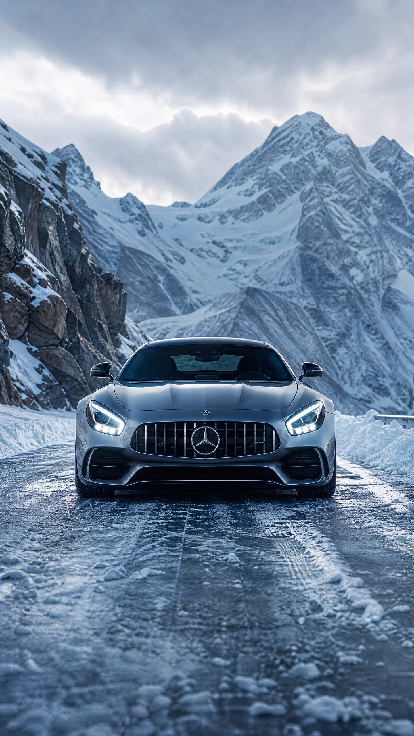 Silver Mercedes Sports Car Parked on Snow-Covered Mountain Pass Road Silver Mercedes sports car on snowy mountain road