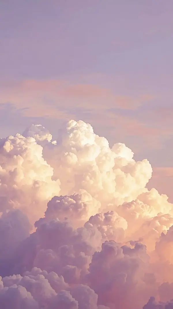soft fluffy cumulus clouds in pastel pink and purple colors under a warm glowing sky