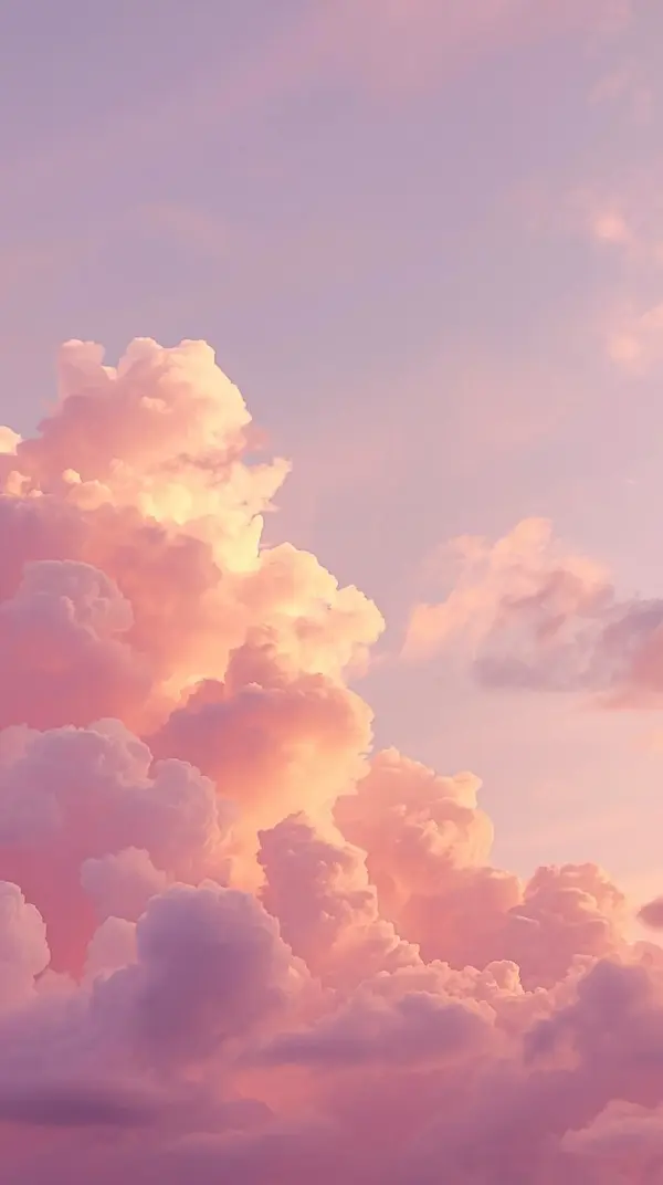 fluffy pink and peach clouds in a soft lavender sky under warm golden hour light