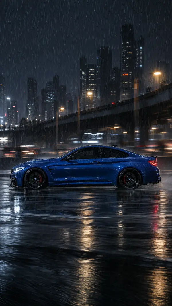 Blue BMW M4 coupe on a rainy city street at night